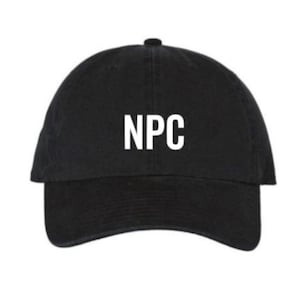 Puede incluir: Una gorra de béisbol negra con la palabra "NPC" bordada en blanco en la parte delantera.