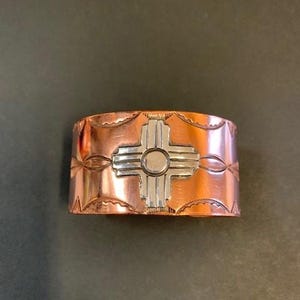 Brazalete de cobre y plata de ley elaborado por Navajo con diseño Zia de Nuevo México 27959