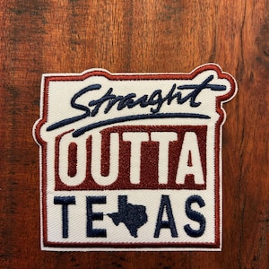 Op de afbeelding: Geborduurde patch met de woorden "Straight Outta Texas" in marineblauwe letters en blokletters. De patch heeft een witte achtergrond met een rode rand en een marineblauwe omtrek van de staat Texas.