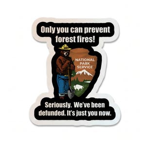 Puede incluir: Una pegatina con Smokey Bear, la mascota del Servicio de Parques Nacionales, sosteniendo una pala. La pegatina tiene el texto "Only you can prevent forest fires!" y "Seriously. We've been defunded. It's just you now."