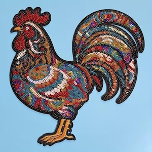 Pode incluir: Um patch de galo colorido com uma borda preta. O patch apresenta um design vibrante de lantejoulas vermelhas, azuis, douradas e verdes. A crista e a barbela do galo são vermelhas, e seu bico é amarelo. O fundo é azul claro.