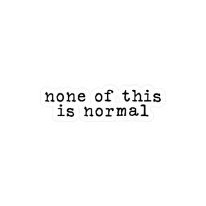 May include: A white sticker featuring the text "none of this is normal" in a black, typewriter-style font. The words are centrally aligned on the sticker.