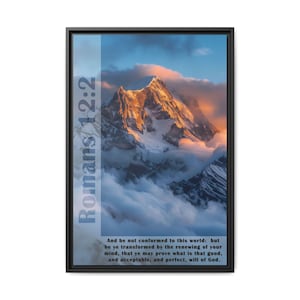 May include: A framed print with a mountain range in the background. The sky is a vibrant orange and pink with clouds. The text "Romans 12:2" is on the left side of the image. The text below the mountain range reads "And be not conformed to this world: but be ye transformed by the renewing of your mind, that ye may prove what is that good, and acceptable, and perfect, will of God."