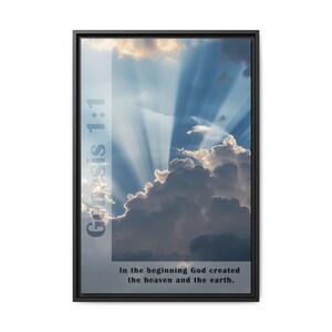 May include: A framed print with a black frame and a sky with clouds and sunbeams. The text "Genesis 1:1" and "In the beginning God created the heaven and the earth." is printed on the image.