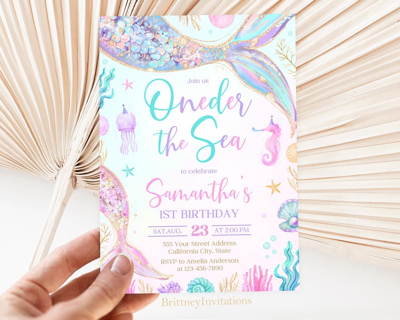 May include: A light blue and pink invitation with a mermaid tail and the text "Join us Oneder the Sea to celebrate Samantha's 1st Birthday SAT AUG 23 AT 2:00 PM 555 Your Street Address California City, State RSVP to Amelia Anderson at 123-456-7890 Brittney Invitations".