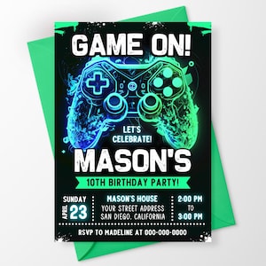 May include: A rectangular birthday invitation card featuring a black background with a glowing neon blue and green video game controller graphic. The text reads GAME ON! LET'S CELEBRATE! MASON'S 10TH BIRTHDAY PARTY! with event details for April 23rd.