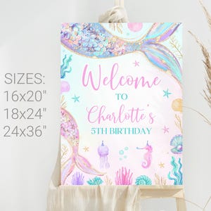 May include: A pink and blue mermaid-themed welcome sign with the text "Welcome to Charlotte's 5th Birthday". The sign features a mermaid tail with glitter and a starfish, seashells, and jellyfish.