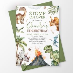May include: A rectangular birthday invitation card featuring watercolor illustrations of various dinosaurs, palm leaves, and a volcanic eruption. The text reads STOMP ON OVER TO CELEBRATE Charlie's 5TH BIRTHDAY, with event details including date, time, and location.