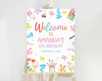 Può includere: Un cartello bianco con la scritta "Welcome to Amanda's 6th Birthday November 24, 2025", circondato da illustrazioni ad acquerello di materiali artistici. Il design include tubetti di vernice, pennelli, tavolozze e schizzi di vernice colorati.