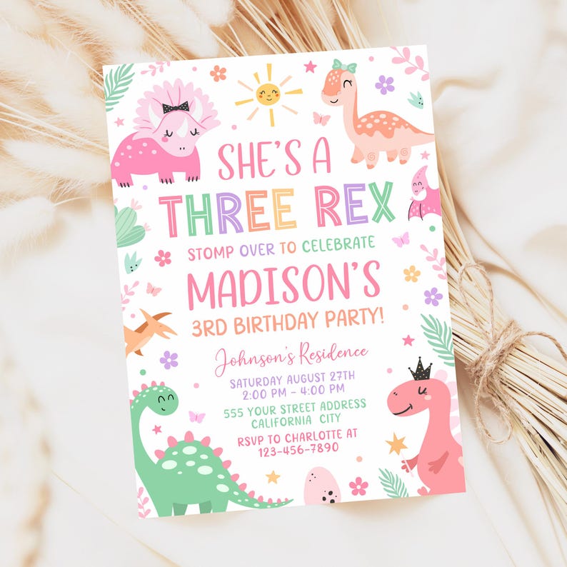 May include: A rectangular birthday party invitation featuring pink, green, and orange dinosaurs, flowers, and a sun. The text reads: SHE'S A THREE REX, STOMP OVER TO CELEBRATE MADISON'S 3RD BIRTHDAY PARTY, Johnson's Residence, Saturday August 27th, 2:00 PM - 4:00 PM, 555 Your Street Address, California City, RSVP to Charlotte at 123-456-7890.