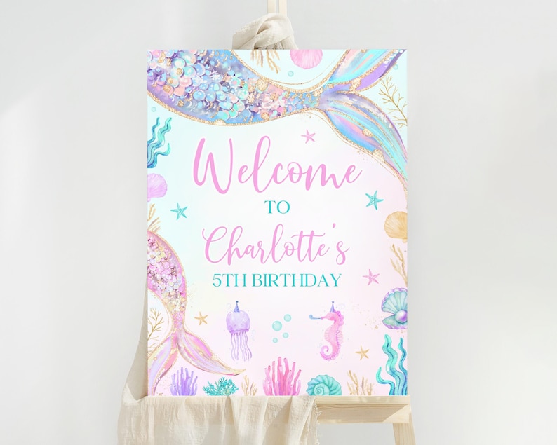 May include: A pink and blue mermaid-themed welcome sign with the text "Welcome to Charlotte's 5th Birthday". The sign features a mermaid tail with iridescent scales, seashells, starfish, and a seahorse.