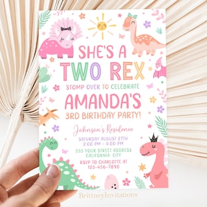 Puede incluir: Una invitación de fiesta de cumpleaños de dinosaurio rosa y verde con el texto "She's a Two Rex" y "Amanda's 3rd Birthday Party!" La invitación incluye una fecha, hora y lugar para la fiesta.