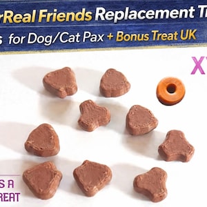 Op de afbeelding: Bruine, hartvormige traktatiepellets voor huisdieren en een oranje, ringvormige traktatie liggen verspreid op een witte ondergrond. De afbeelding bevat de tekst: "10x FurReal Friends Replacement Treat Pellets for Dog/Cat Pax + Bonus Treat UK", "X10" en "INCLUDES A BONUS TREAT".