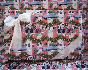 Può includere: Una scatola regalo rettangolare avvolta in carta con un motivo di auto d'epoca con alberi di Natale, donne in abbigliamento invernale e ghirlande verdi. Un nastro color crema trasparente è legato a fiocco sul lato sinistro.