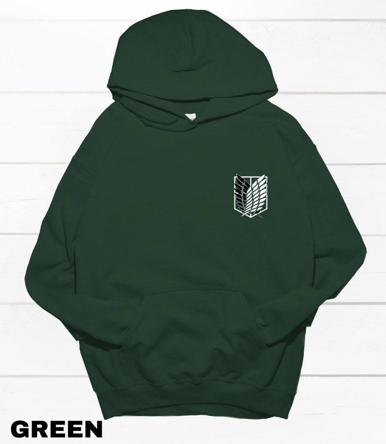May include: A dark green hooded sweatshirt with a white graphic of the Attack on Titan logo on the front.