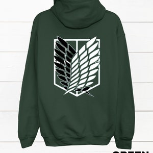 May include: A dark green hooded sweatshirt with a white and black graphic of the Attack on Titan symbol on the back.