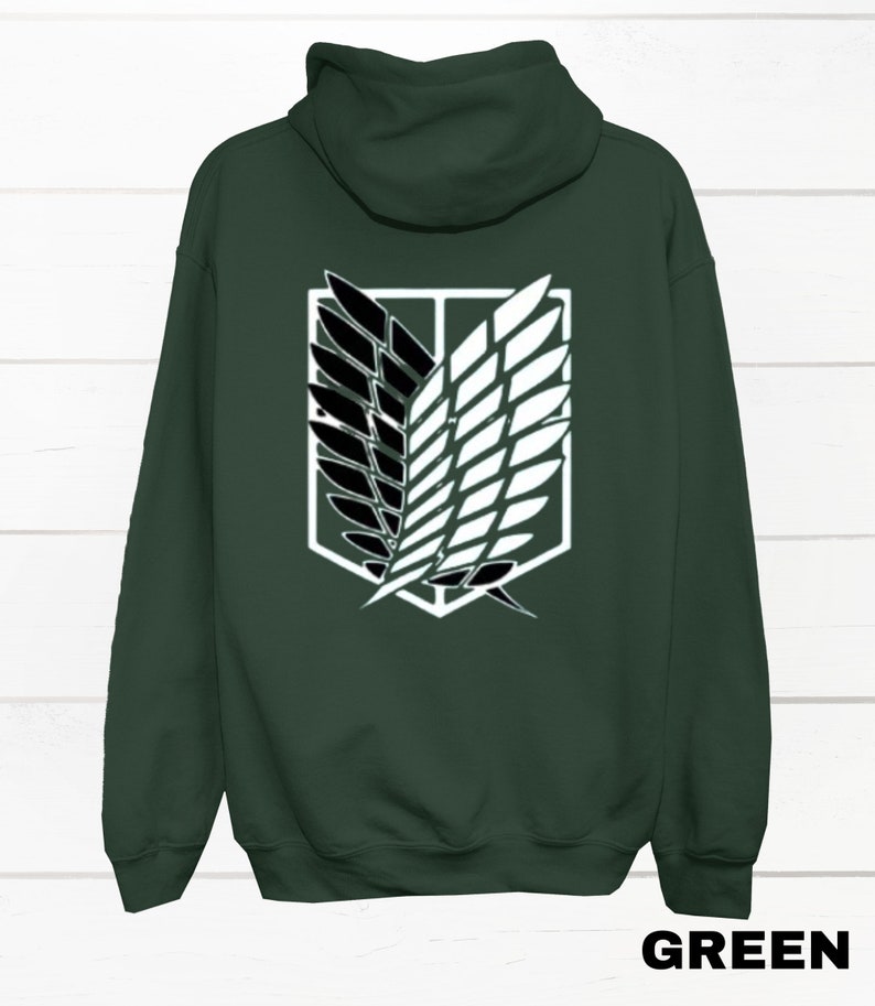 May include: A dark green hooded sweatshirt with a white and black graphic of the Attack on Titan symbol on the back.
