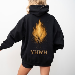 May include: Black hoodie featuring a golden flame tree design on the back, with the word "YWHW" in gold lettering below the tree. The hoodie has a hood and long sleeves.