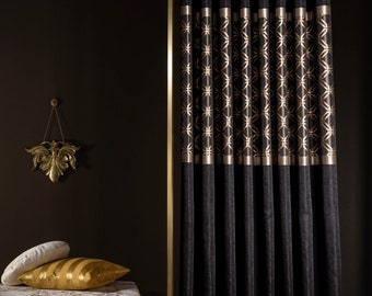 Puede incluir: Cortinas de terciopelo negro con un patrón geométrico dorado. Las cortinas están forradas con un ribete dorado.