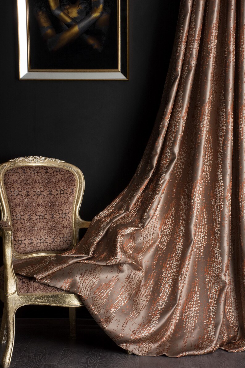 Op de afbeelding: Een luxueus interieur met een goudomrand kunstwerk, een vintage stoel met sierlijke details en vloeiende bruine gordijnen. De gordijnen hebben een textuurpatroon, wat diepte en elegantie toevoegt aan de kamerinrichting.