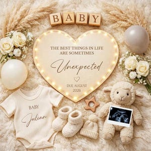 Könnte beinhalten: Baby-Ankündigung mit einem herzförmigen Schild mit der Aufschrift "THE BEST THINGS IN LIFE ARE SOMETIMES Unexpected DUE AUGUST 2026." Das Bild zeigt Babykleidung, ein Stofflamm und einen Ultraschall.