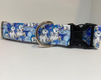 May include: A blue and white dog collar with a silver D-ring and a black buckle. The collar features a repeating pattern of white cartoon horses with blue wings and gold halos on a blue background.