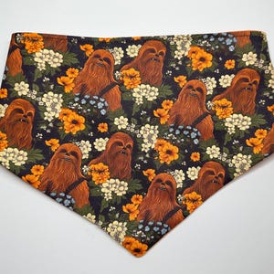 May include: A brown bandana with a floral pattern featuring a repeating image of Chewbacca from Star Wars.