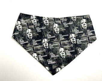 May include: Black and white patterned bandana featuring a repeating design of a horror movie mask, a knife, and the phrases "IT'S TIME MICHAEL" and "THE NIGHTMARE ISN'T OVER".