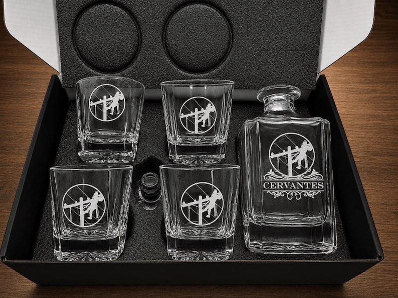Personalized Lineman decanter engraved with the Cervantes name and four standard Lineman-emblem rocks glasses arranged in a black gift box.