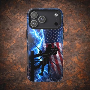 Puede incluir: Una funda de teléfono con un diseño que presenta la bandera estadounidense, una silueta de un liniero y rayos azules. La funda tiene un módulo de cámara negro con tres lentes.