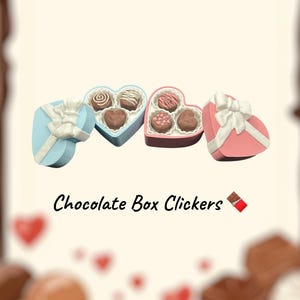 May include: Four heart-shaped boxes in blue, pink, and white, each with a white bow and filled with chocolates. The text "Chocolate Box Clickers" is below the boxes.