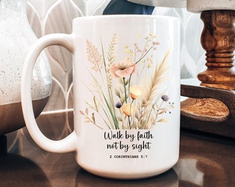 Könnte beinhalten: Weiße Keramiktasse mit Blumenmuster und dem Text "Geht im Glauben, nicht im Ansehen 2 Korinther 5,7".