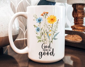 Könnte beinhalten: Eine weiße Keramiktasse mit Blumenmuster und dem Text "God, you're so good".