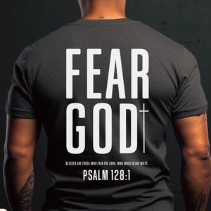 May include: Dark heather grey t-shirt with the words "FEAR GOD" in large white letters. A white cross is centered below the word "GOD". The text "BLESSED ARE THOSE WHO FEAR THE LORD, WHO WALK IN HIS WAYS. PSALM 128:1" is printed below.