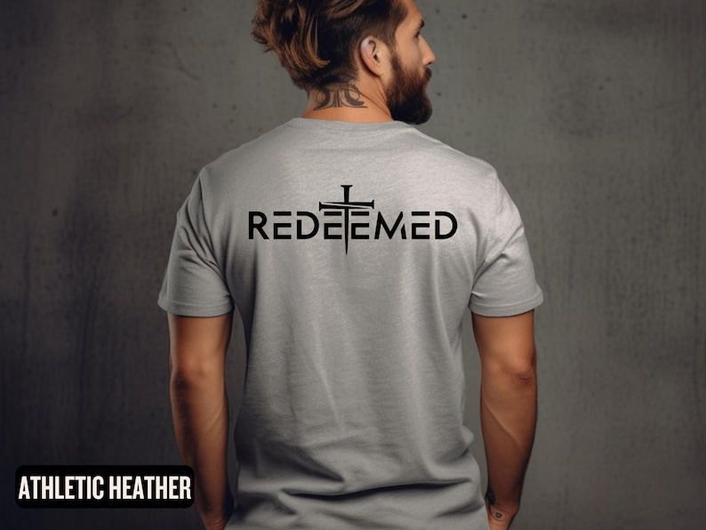 May include: A gray t-shirt with the word "REDEEMED" printed on the back in black lettering. A black cross with nails is above the word.