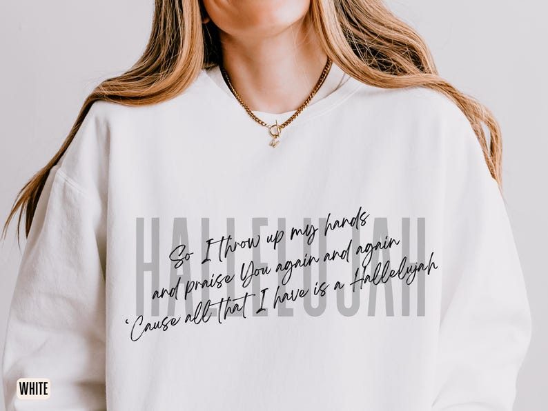 May include: A white crewneck sweatshirt featuring the word HALLELUJAH in large gray capital letters. Overlaid in black cursive script is the text: So I throw up my hands and praise You again and again 'Cause all that I have is a Hallelujah.