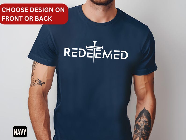 May include: A navy blue t-shirt with a white cross and the word "REDEEMED" printed on the front.