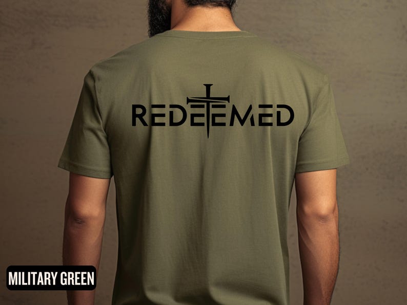 May include: A military green t-shirt with a black graphic of a cross with nails and the word "REDEEMED" underneath.