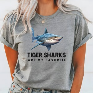 May include: A gray t-shirt with a blue tiger shark graphic and the text "Tiger Sharks Are My Favorite".