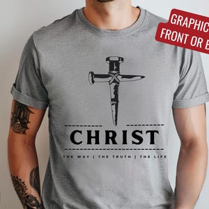 May include: Gray t-shirt with a graphic of a nail hammered into a cross. The text "CHRIST" is below the graphic, with the words "THE WAY | THE TRUTH | THE LIFE" underneath.