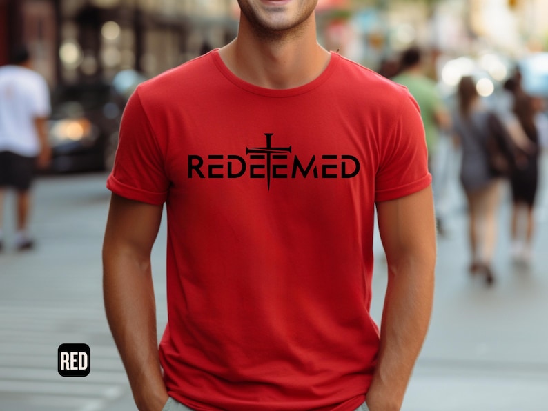 May include: A red t-shirt with a black cross and the word "REDEEMED" printed on the front.