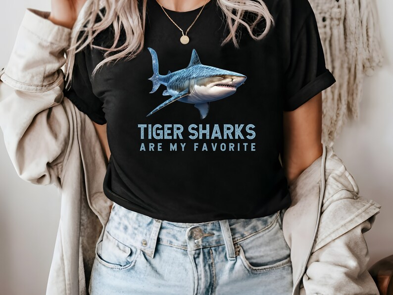May include: A black t-shirt with a blue tiger shark graphic and the text "Tiger Sharks Are My Favorite".
