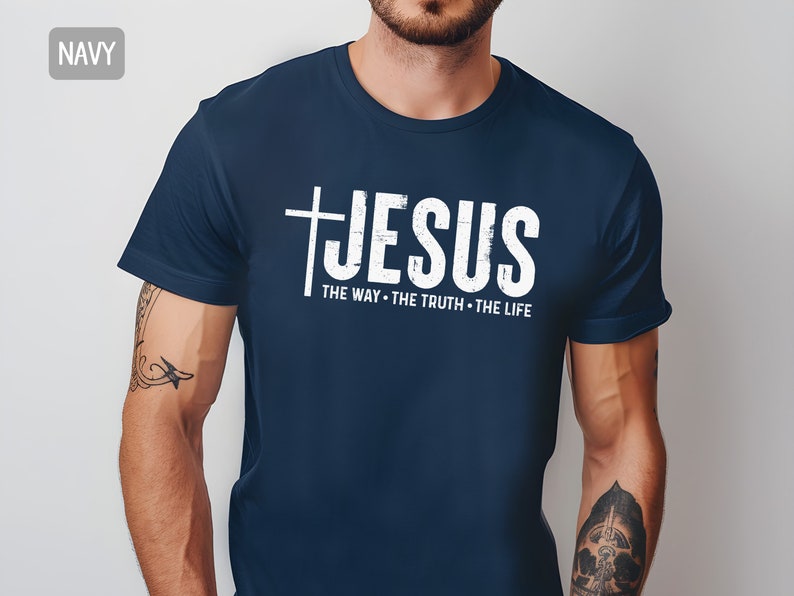 May include: A navy blue t-shirt with a white distressed graphic of a cross and the word "JESUS" with the text "THE WAY - THE TRUTH - THE LIFE" underneath.