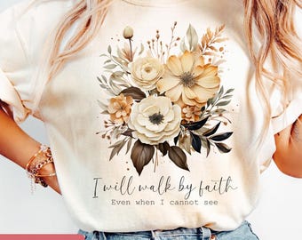 May include: A white t-shirt with a floral design in shades of brown and beige. The text "I will walk by faith Even when I cannot see" is printed on the shirt.