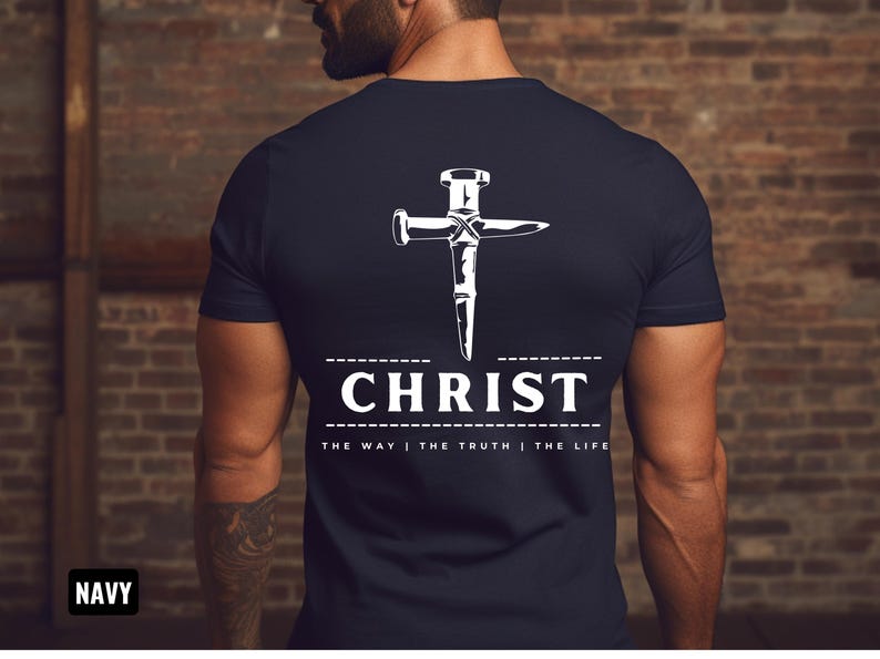 May include: Navy blue t-shirt with a white graphic of a nail hammered into a cross. The text "CHRIST" is below the cross with the phrase "THE WAY | THE TRUTH | THE LIFE" underneath.