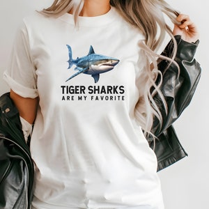 May include: White t-shirt with a blue tiger shark graphic and the text "Tiger Sharks Are My Favorite".