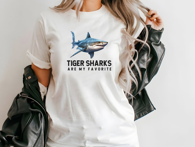 May include: White t-shirt with a blue tiger shark graphic and the text "Tiger Sharks Are My Favorite".