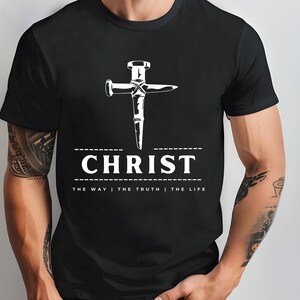 May include: Black t-shirt with a white graphic of a nail hammered into a cross. The text "CHRIST" is below the cross with the phrase "THE WAY | THE TRUTH | THE LIFE" underneath.