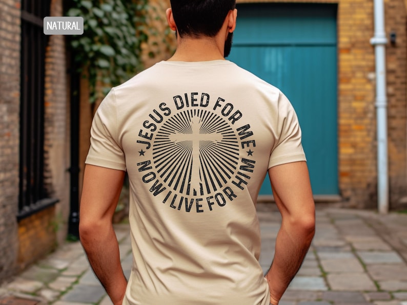 May include: A beige t-shirt with a black graphic on the back. The graphic is a circle with a cross in the center and the text "Jesus Died For Me * Now I Live For Him".