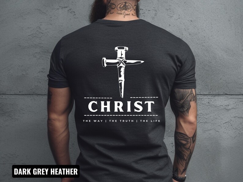 May include: Dark grey heather t-shirt with a white graphic of a nail hammered into a cross. The text "CHRIST" is below the cross with the phrase "THE WAY | THE TRUTH | THE LIFE" underneath.